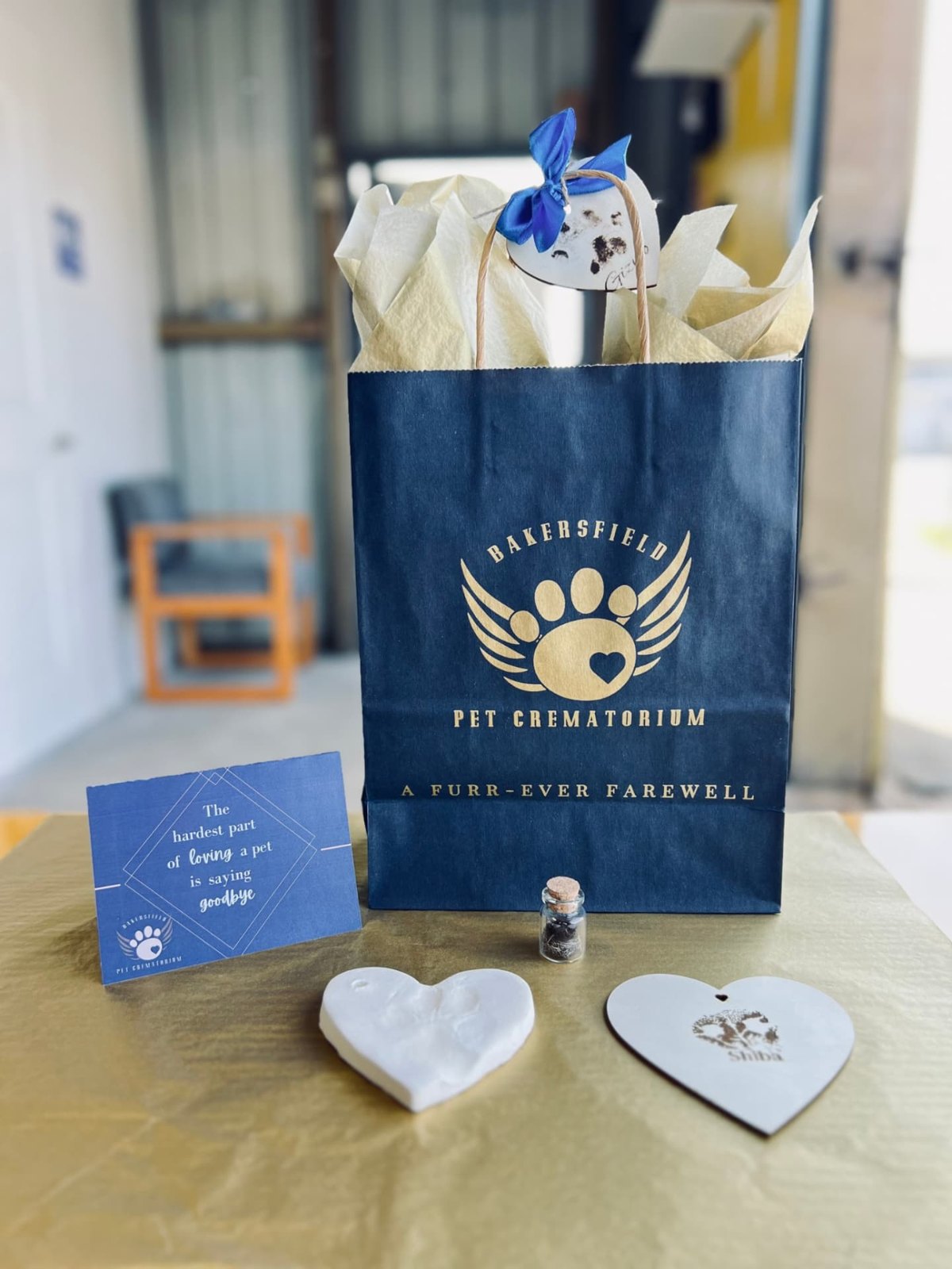 Memorial keepsakes including paw-print tokens and a personalized “A Furr-Ever Farewell” bag for a beloved pet